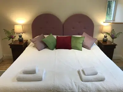 a large white bed with two pillows on it at Ederline Farm Cottage in Lochgilphead