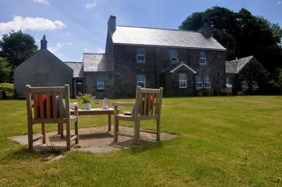 a table and two chairs in front of a house at Finchairn Farmhouse in Lochgilphead