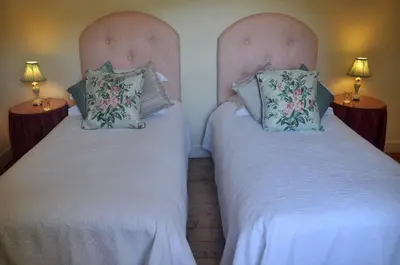 two twin beds in a room with two lamps at Finchairn Farmhouse in Lochgilphead