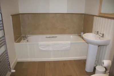 a bathroom with a tub and a sink and a toilet at School Room in Lochgilphead