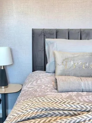 a bedroom with a bed with a gray headboard at Bright and Cozy 3BR Home Near Hampden Park in Glasgow