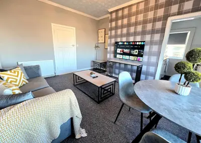 a living room with a couch and a table at Bright and Cozy 3BR Home Near Hampden Park in Glasgow