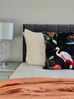 a bed with a pillow and a bird on it at Bright and Cozy 3BR Home Near Hampden Park in Glasgow