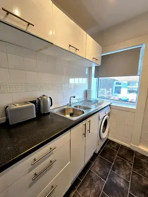 a kitchen with a sink and a washing machine at Bright and Cozy 3BR Home Near Hampden Park in Glasgow