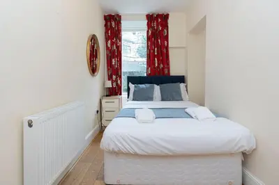a bedroom with a large bed and a window at Gardners Crescent in Edinburgh