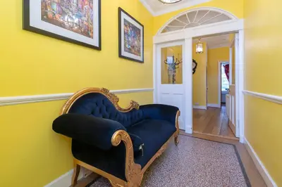 a blue couch in a room with a yellow wall at Gardners Crescent in Edinburgh