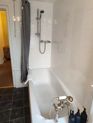 a bathroom with a bath tub with a shower at Fintry Inn in Fintry