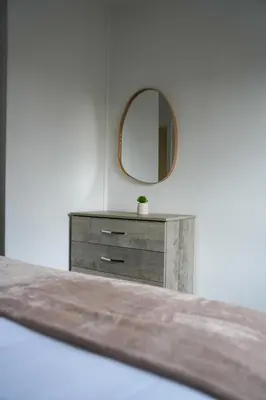 a dresser in a room with a mirror at Simpson House in Tillicoultry