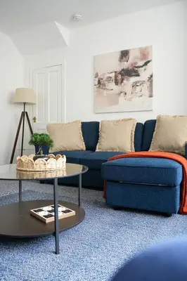 a living room with a blue couch and a table at Simpson House in Tillicoultry