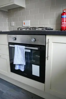 a kitchen with a stove with a towel hanging from it at Simpson House in Tillicoultry