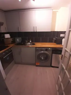 a kitchen with a sink and a washing machine at Warm Central Apartment by Meadows 7 in Edinburgh