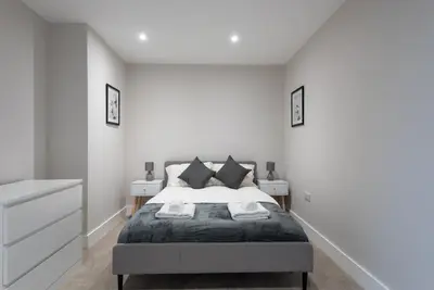 a white bedroom with a bed and two night stands at Chic 1Bed in Hull City Centre near Hull College in Moffat