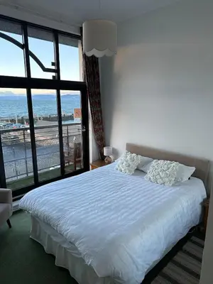 a bedroom with a bed with a view of the ocean at Seaside Penthouse in Largs