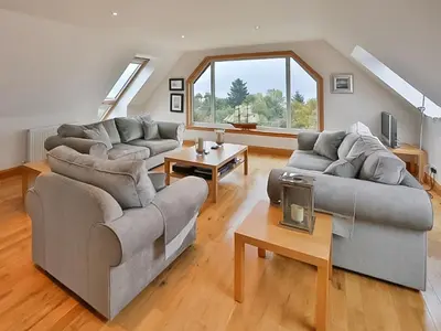 a living room with two couches and a table at Tanglewood in Whiting Bay