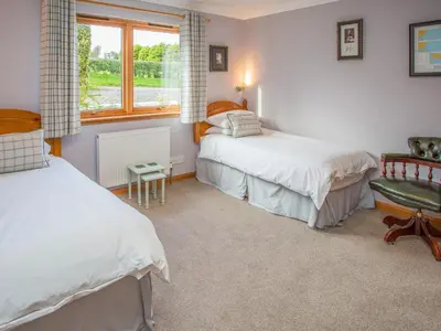 a bedroom with two beds and a window at Tanglewood in Whiting Bay