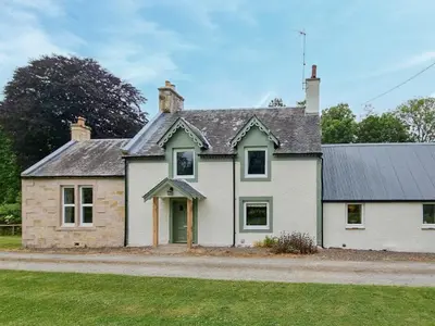 a white house with a green door on a street at Lady Farm in Girvan