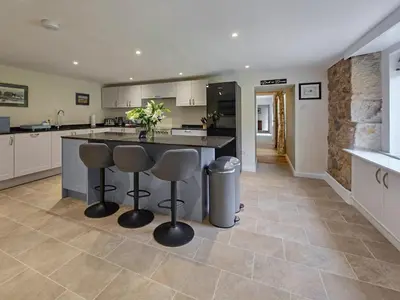 a kitchen with a island with two bar stools at Lady Farm in Girvan