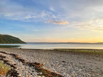 a rocky beach with a large body of water at The Green in Lochranza
