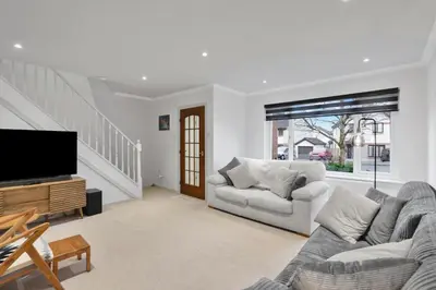 a living room with a couch and a flat screen tv at Stylish 3-Bed Home with Private Garden in Airdrie in Airdrie
