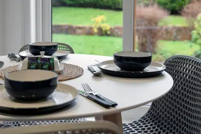 a table with plates and bowls on top of it at Stylish 3-Bed Home with Private Garden in Airdrie in Airdrie