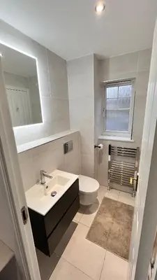 a bathroom with a sink and a toilet and a mirror at Modern 5 bedroom Getaway Free Parking in Hurlet