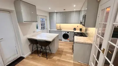 a kitchen with white cabinets and a counter top at Modern 5 bedroom Getaway Free Parking in Hurlet