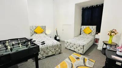 a living room with two beds and a foos ball at Spacious 3 Bedroom Entire Apartment Self Check in & Free Parking in Cowdenbeath