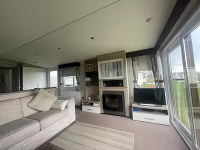 a living room with a couch and a tv at Shells at Sandylands in Stevenston