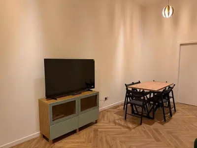 a living room with a television on a cabinet with a table at Acorn Spacious Stay Glasgow in Glasgow