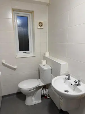 a white bathroom with a toilet and a sink at Acorn Spacious Stay Glasgow in Glasgow
