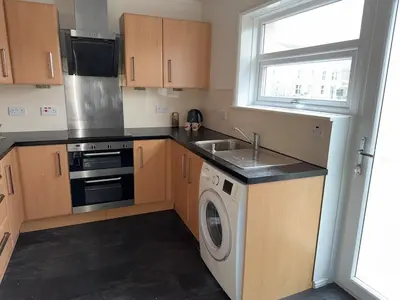 a kitchen with a washing machine and a sink at Spacious Glasgow Group Stay in Glasgow