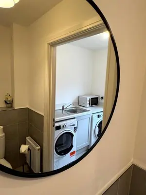 a bathroom with a washer and dryer in a mirror at Luxury 4BR Detached Exec Home in Cadzow