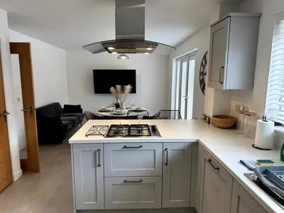 a kitchen with a stove top oven next to a living room at Luxury 4BR Detached Exec Home in Cadzow