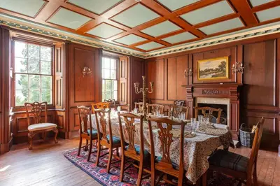 a dining room with a table and chairs and a fireplace at Old Argyll House in Rashfield