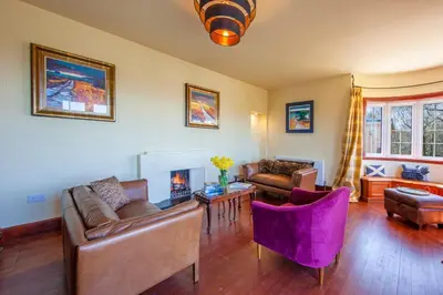 a living room with couches and a fire place at Oban Bay Hall in Dunollie