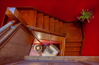 an overhead view of a wooden staircase with a red wall at Oban Bay Hall in Dunollie