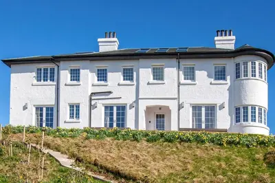 a large white house with two towers on top of a hill at Oban Bay Hall in Dunollie
