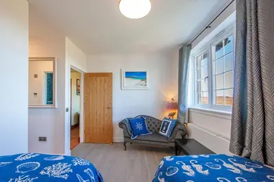 a bedroom with a bed and a chair and a window at Oban Bay Hall in Dunollie