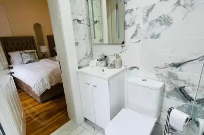 a bathroom with a sink and a toilet and a bed at Glasgow City View Retreat in Glasgow