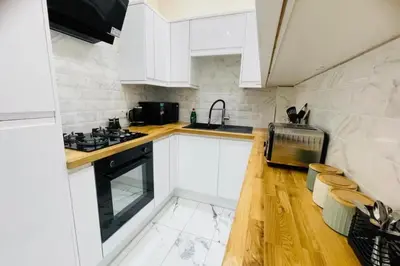 a kitchen with white cabinets and a stove top oven at Glasgow City View Retreat in Glasgow
