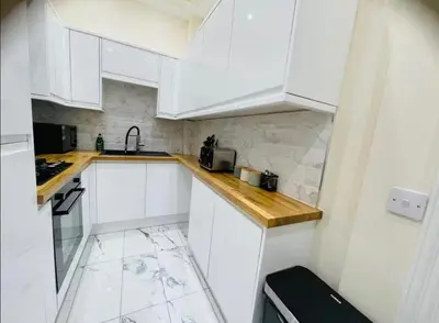 a white kitchen with white cabinets and a sink at Glasgow City View Retreat in Glasgow