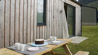 a picnic table with a cake on top of it at Auch - Trail Cabins in Bridge of Orchy