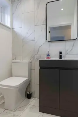 a bathroom with a toilet and a sink and a mirror at Contractor & Family Friendly House - Sleeps 8 - FREE Parking and Fast Wi-Fi in Uphall
