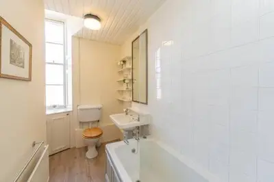 a bathroom with a toilet and a sink and a tub at Top floor, central, spacious, period apartment with park views in Edinburgh