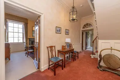 a living room with a table and chairs in a room at Top floor, central, spacious, period apartment with park views in Edinburgh