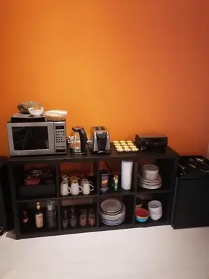a shelf with a microwave and dishes on it at King size bed Direct bus to city center Silver in Edinburgh