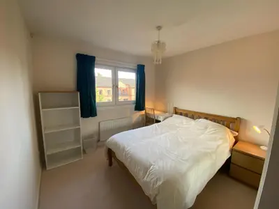 a bedroom with a white bed and a window at Modern central 2 bedroom flat with private parking in Glasgow