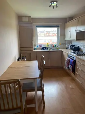 a kitchen with a wooden table and a table and chairs at Modern central 2 bedroom flat with private parking in Glasgow