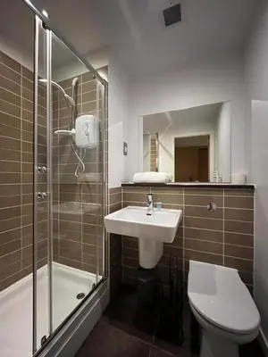 a bathroom with a sink and a shower and a toilet at City centre stylish apartment in Glasgow