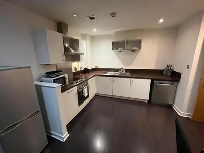 a large kitchen with white cabinets and appliances at City centre stylish apartment in Glasgow
